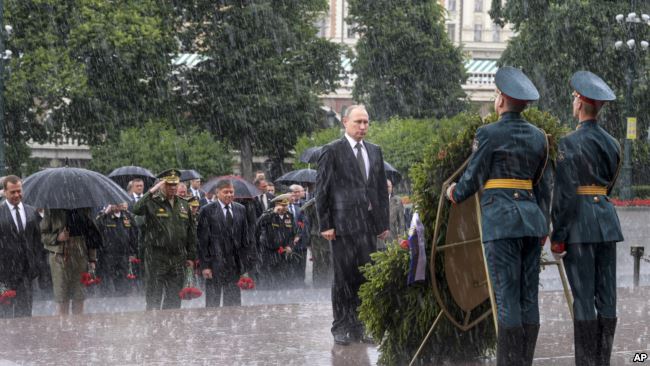 Tổng thống Nga Vladimir Putin đứng nghiêm dưới trời mưa to trong dịp tới viếng mộ chiến sĩ vô danh ở thủ đô Moscow hồi t