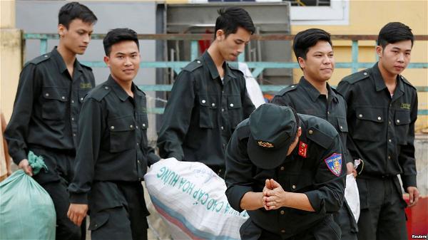 Một cảnh sát cúi đầu cảm tạ dân làng Đồng Tâm sau khi được phóng thích hôm 22 tháng Tư. (Hình REUTERS-Kham)