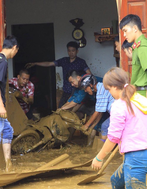 Thanh niên tình nguyện H.Mù Cang Chải tìm kiếm tài sản của người dân bị vùi lấp trong bùn đất Ảnh- Vân Kiều