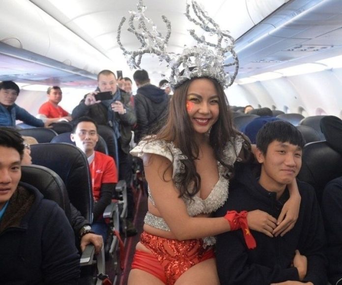 Người mẫu mặc bikini chụp hình với cầu thủ U23 trên chuyến bay của VietJet Air. (Hình Facebook)