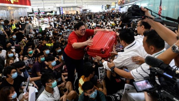 Hành khách vật lộn để vượt qua đám đông trước khi các chuyến bay bị đình chỉ tai san bay Hong Kong 13-8-2019