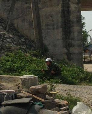 Một người đàn ông với khẩu súng trường gần khu vực nhà thờ giáo họ Văn Thai 