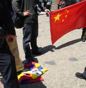 Một người Hoa đang dẫm chân lên lá cờ Tây Tạng (Ảnh Bùi Văn Phú)