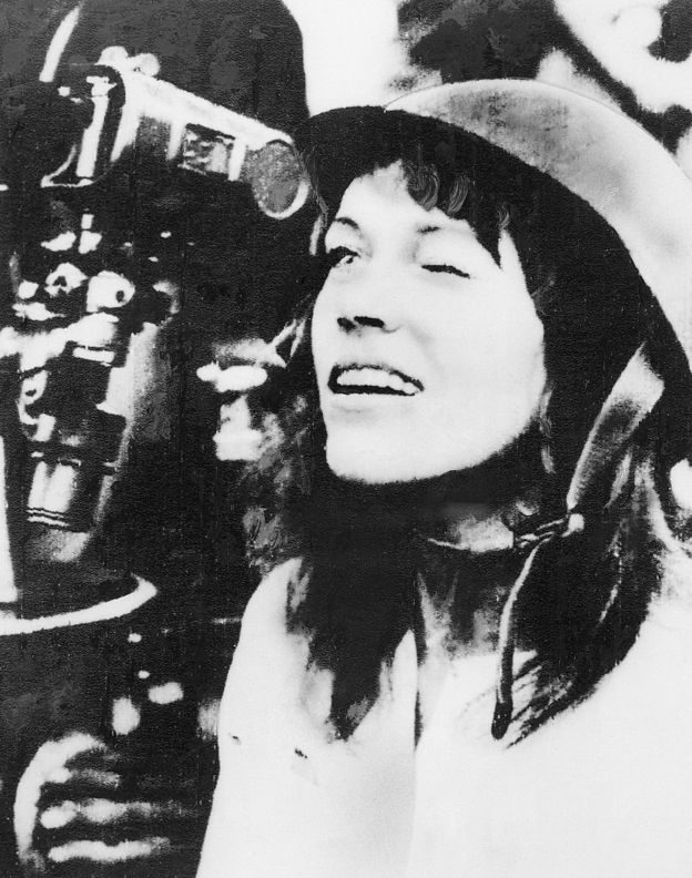 Thăm một đơn vị cao xạ Bắc Việt Nam gần Hà Nội, Jane Fonda đội mũ phòng không và nhìn qua kính ngắm bắn của ụ pháo 